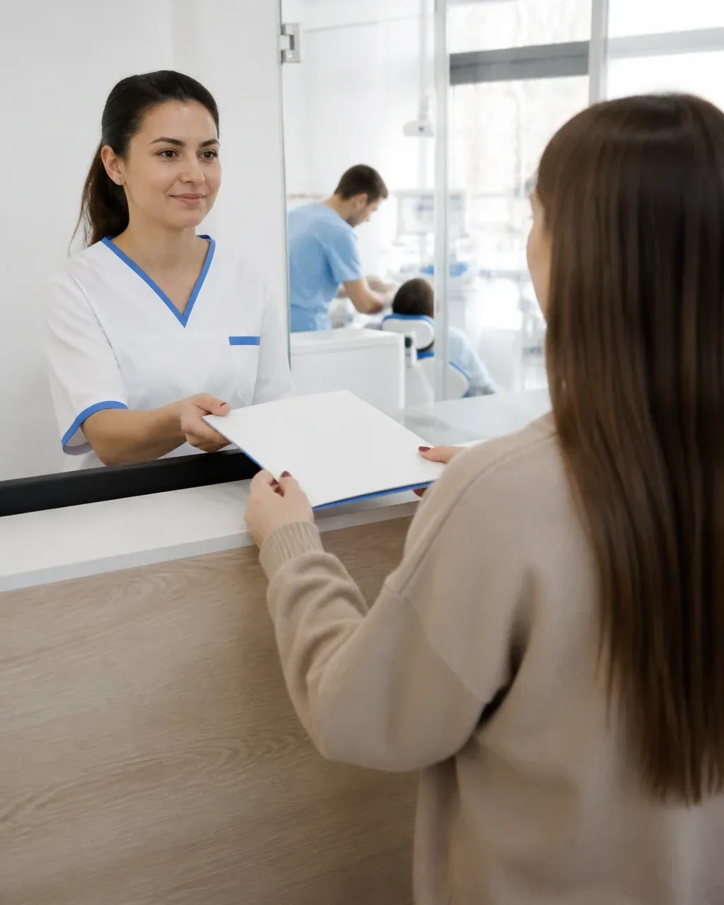 The clinic administrator gives the patient a treatment plan at the front desk