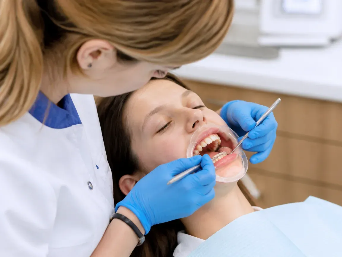 The treatment stage itself: the doctor's gloved hands working in the oral cavity — an illustration for the section "Preparation for Damon bracket placement"