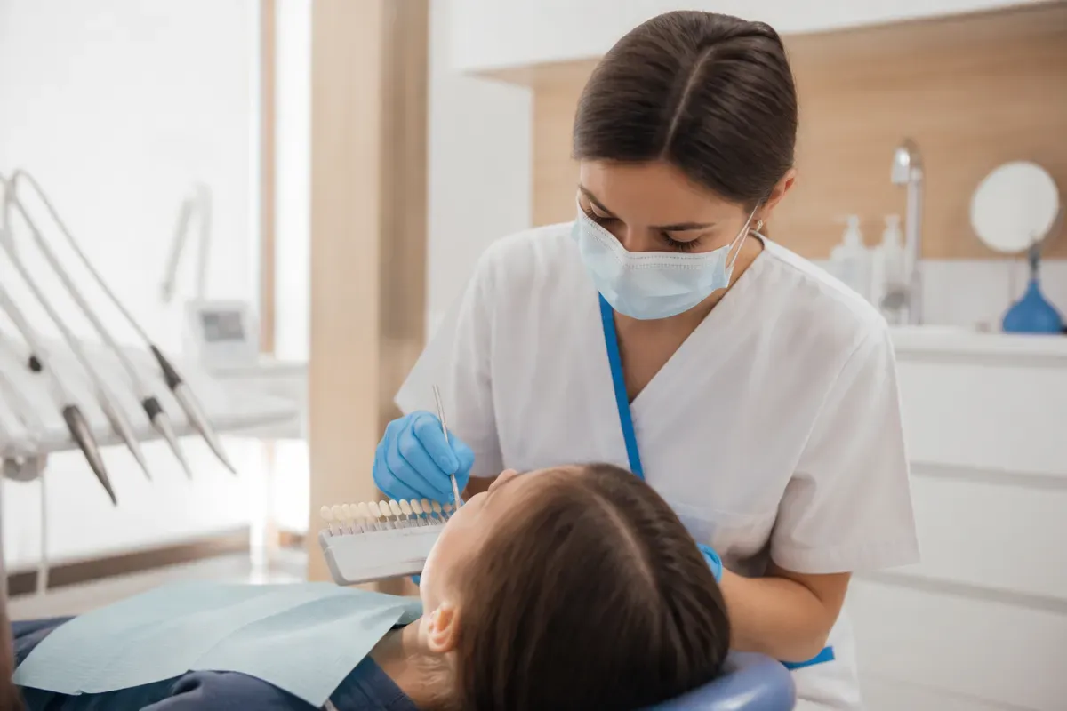 Chairside appointment: dentist at work, over-the-shoulder shot of the assistant — illustration for the "Invisible Options" section