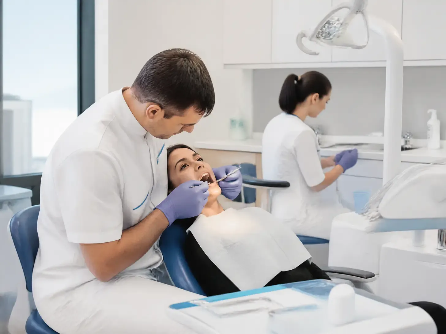 enamel erosion treatment — dentist showing a patient a treatment plan on a screen in a bright office