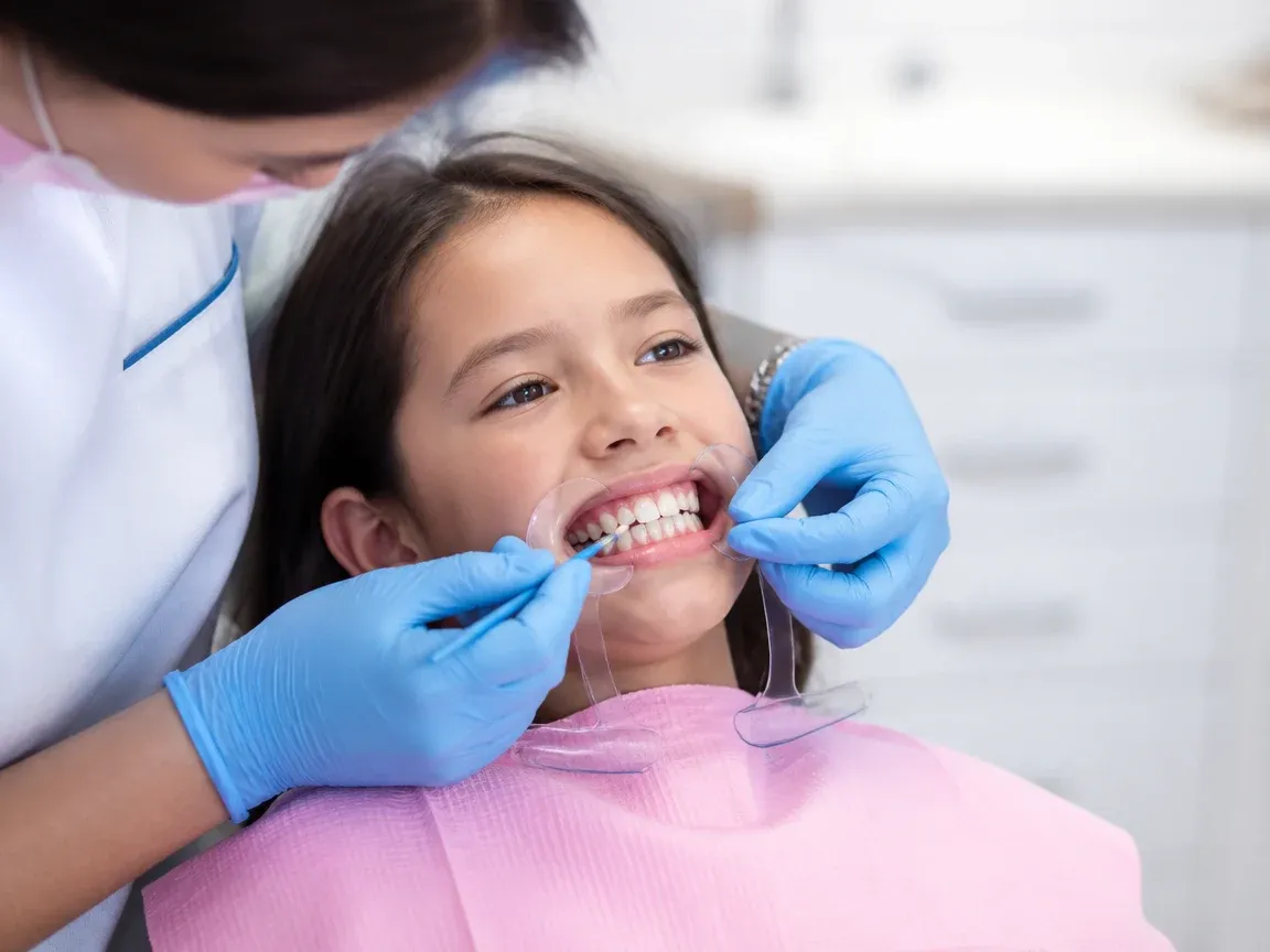 The treatment stage itself: the doctor's gloved hands working inside the oral cavity — an illustration for the section "Applying the composition"