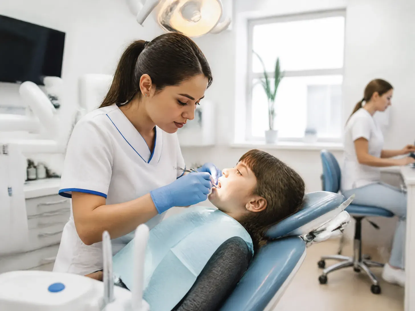gnathologist Astana — doctor showing a patient a treatment plan on screen in a bright office