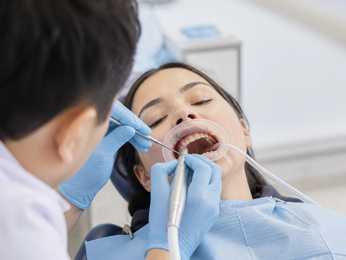 The treatment stage itself: the doctor's gloved hands working in the oral cavity — an illustration for the section "Preparation for surgery"
