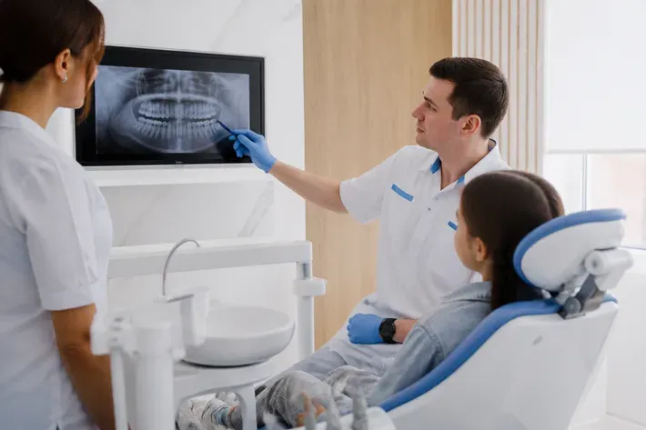 Doctor shows the patient an image on a screen and explains the treatment plan — illustration for the "Clear Aligners" section