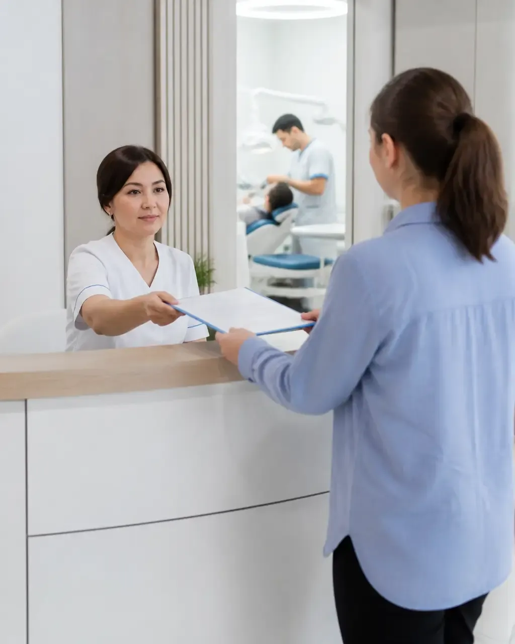 The clinic administrator gives the patient a treatment plan at the front desk