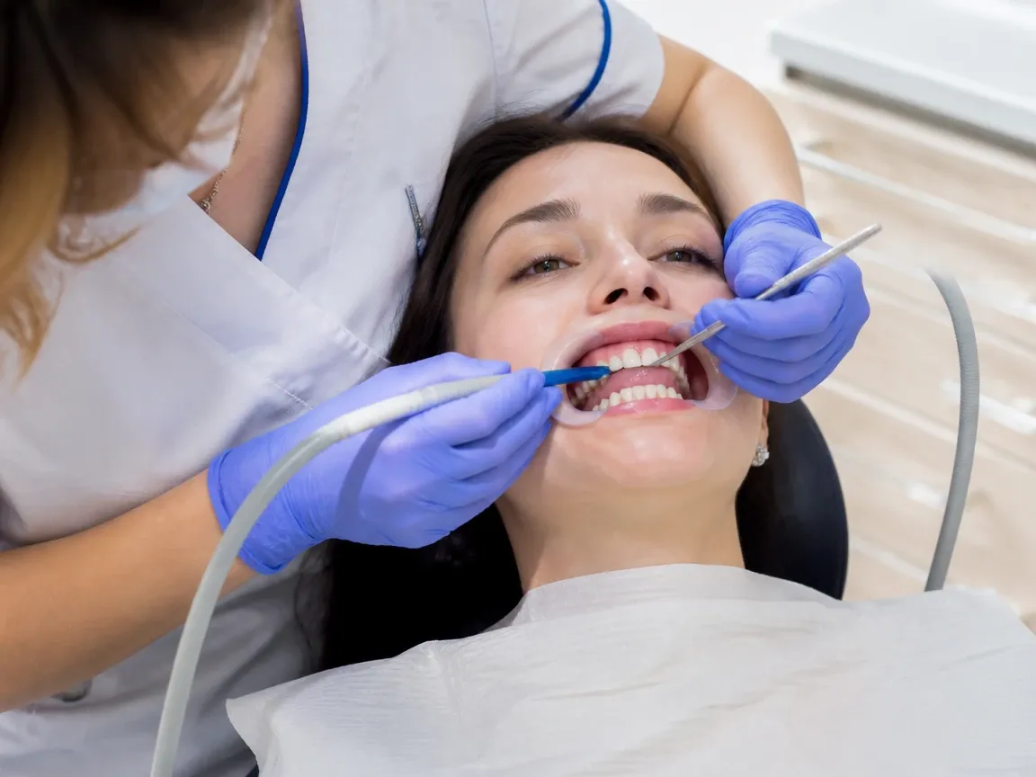 The treatment stage itself: the doctor's gloved hands working inside the oral cavity — an illustration for the "Wearing aligners" section