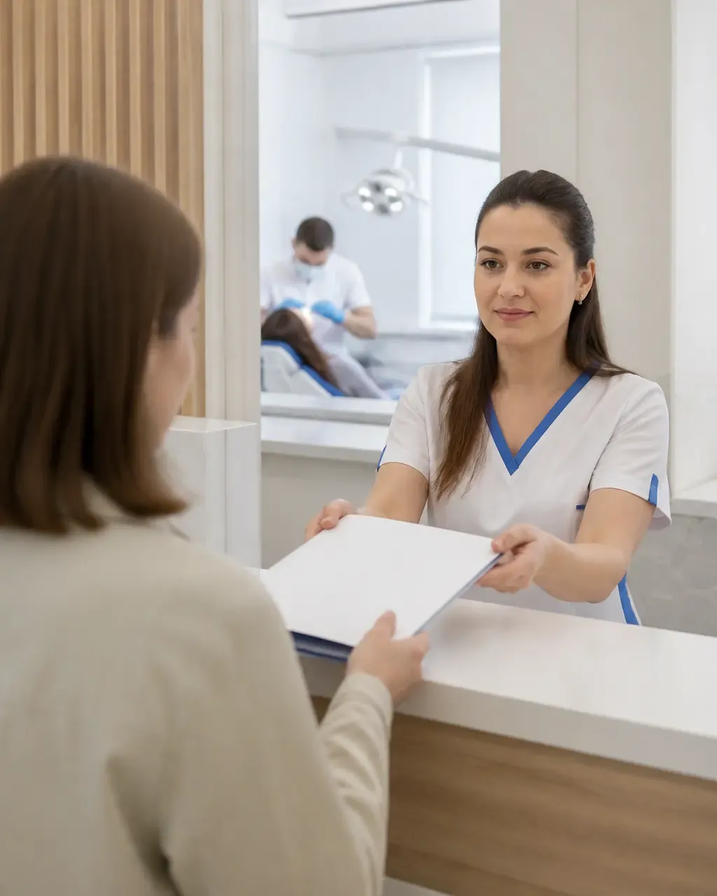 The clinic administrator gives the patient a treatment plan at the front desk