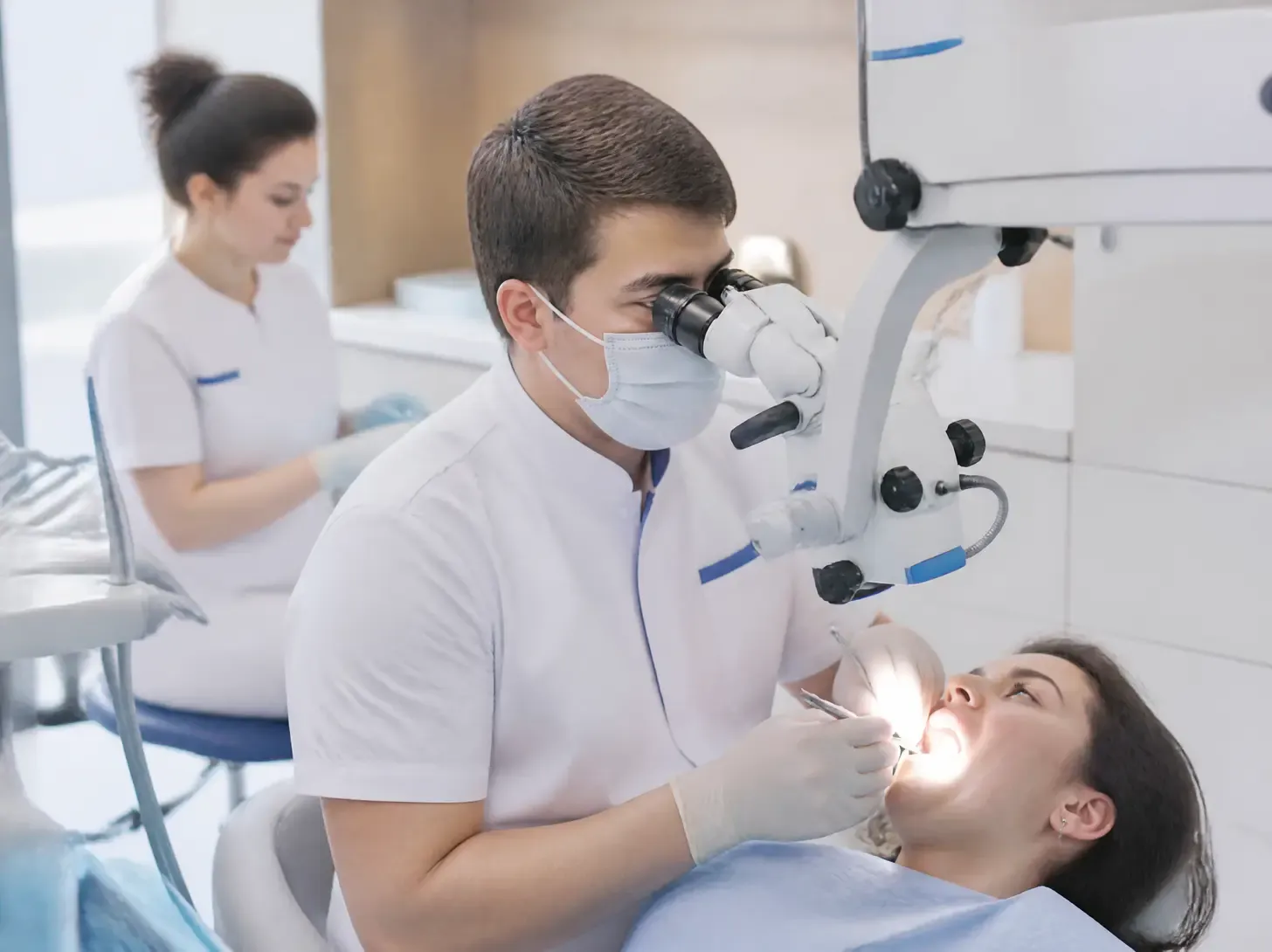 tooth cyst treatment — dentist shows the patient a treatment plan on a screen in a bright office