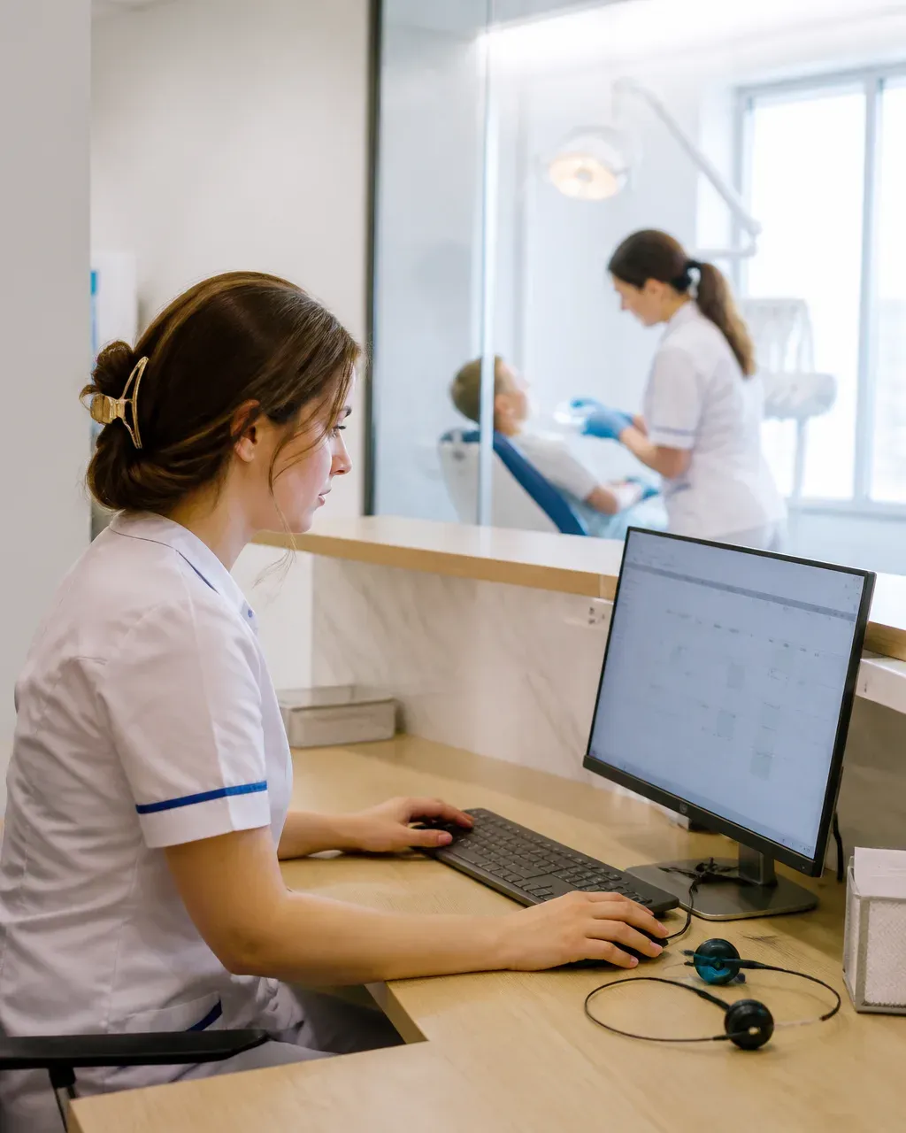 The clinic administrator answers patient messages at the front desk