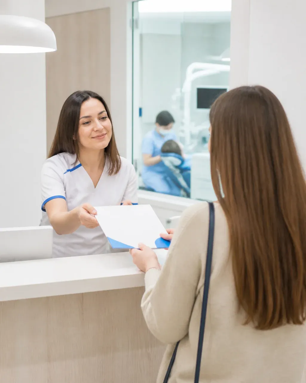 The clinic administrator gives the patient a treatment plan at the front desk