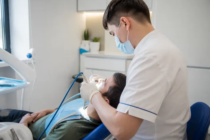 Chairside appointment: dentist at work, over-the-shoulder shot of the assistant — illustration for the section "What results does gum treatment with the Vector device provide and how long do they last?"