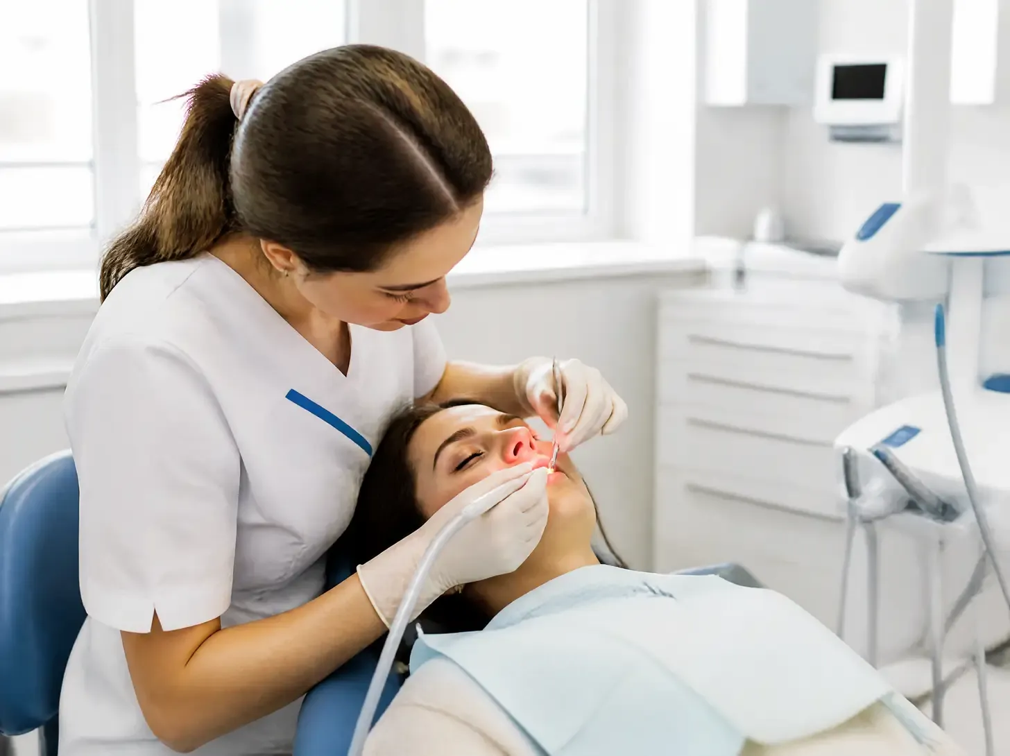 laser gum treatment — dentist showing the patient the treatment plan on a screen in a bright office