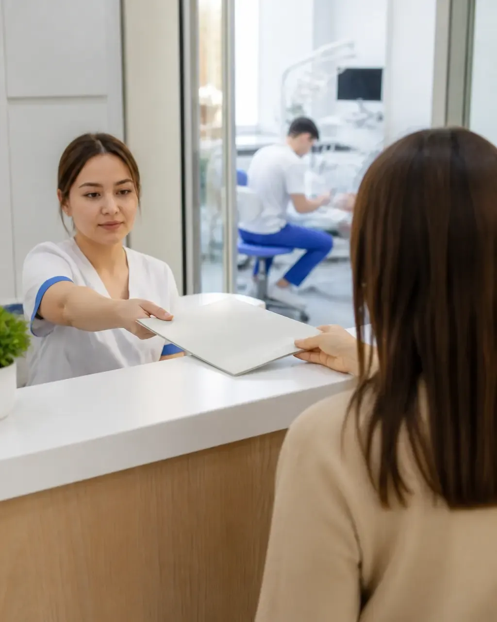 The clinic administrator gives the patient a treatment plan at the front desk