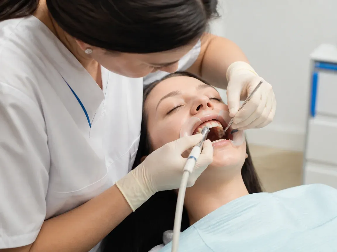The treatment stage itself: the doctor's gloved hands working inside the oral cavity — an illustration for the "Restoration" section