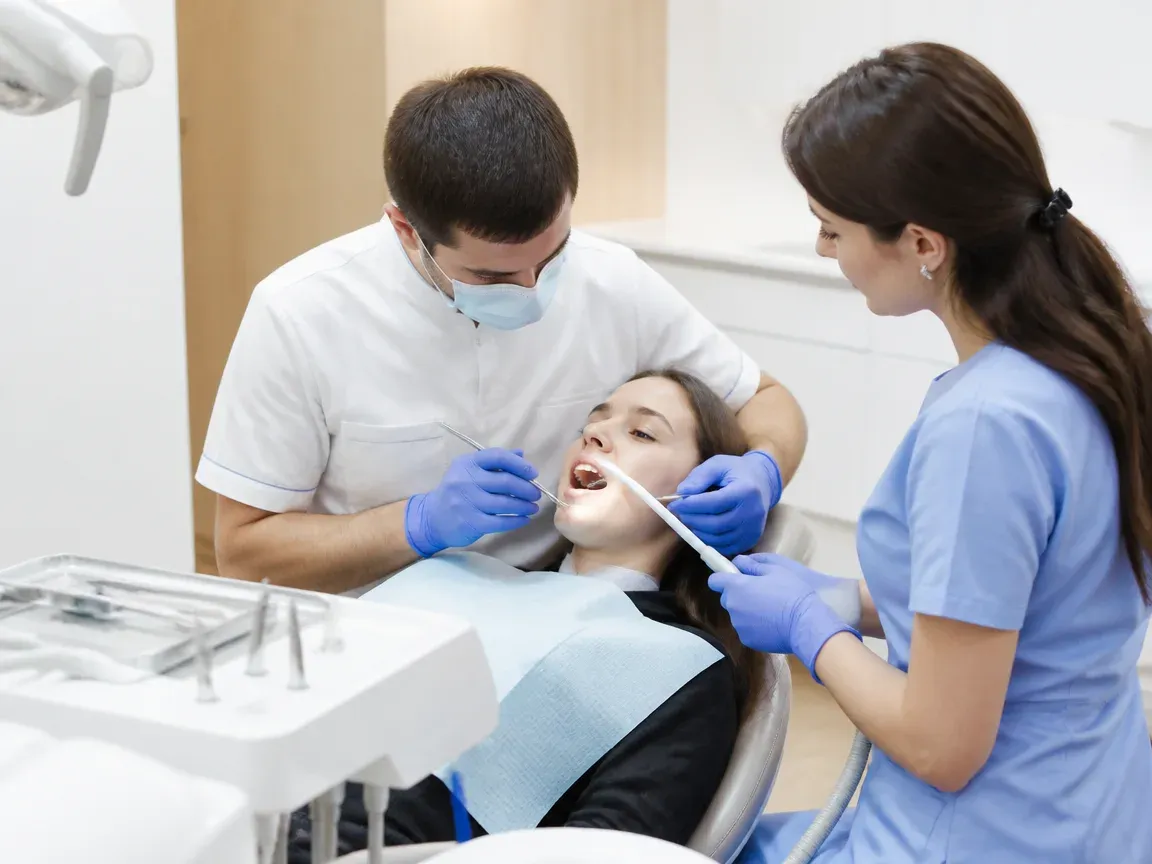 Follow-up visit: the doctor checks the result with a mirror, the assistant holds the saliva ejector — illustration for the "Follow-up examination" section