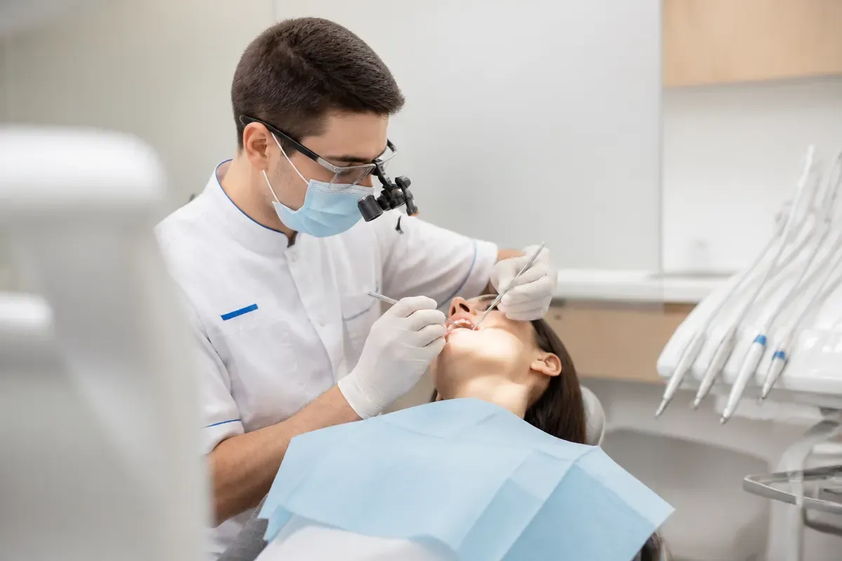 Chairside appointment: dentist at work, over-the-shoulder shot of the assistant — illustration for the "Who provides care" section