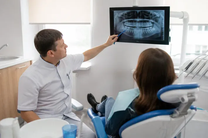 The doctor shows the patient an image on the screen and explains the treatment plan — an illustration for the section "When there are no symptoms"