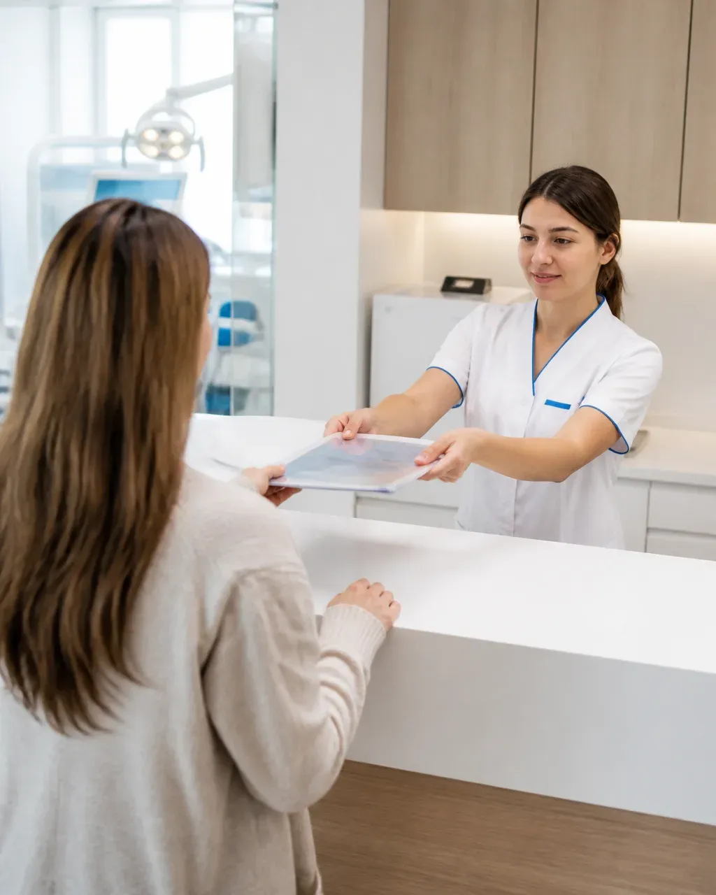 The clinic administrator gives the patient a treatment plan at the front desk