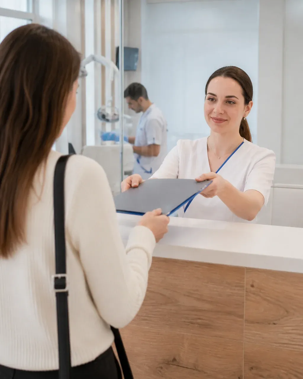 The clinic administrator gives the patient a treatment plan at the front desk