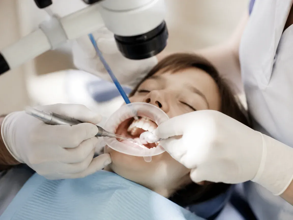 The treatment stage itself: the doctor's gloved hands working in the oral cavity — an illustration for the section "Recovery and Monitoring"