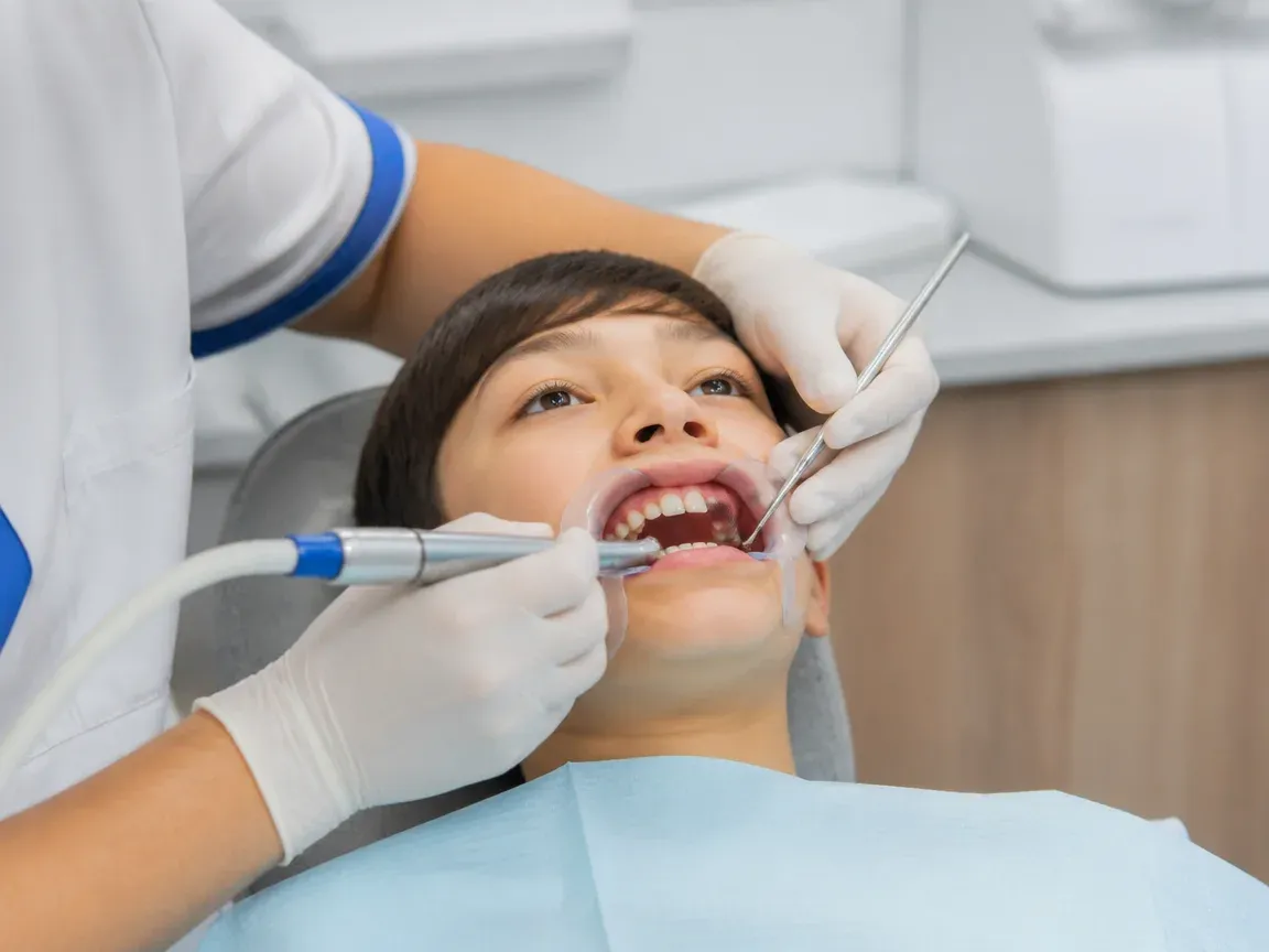 The treatment stage itself: the doctor's gloved hands working in the oral cavity — an illustration for the section "Preparation and Anesthesia"