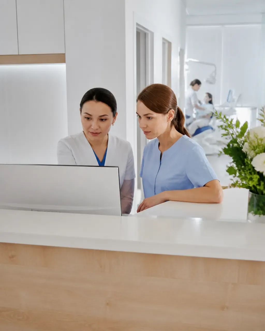 Clinic administrators check the appointment schedule on the screen at the front desk