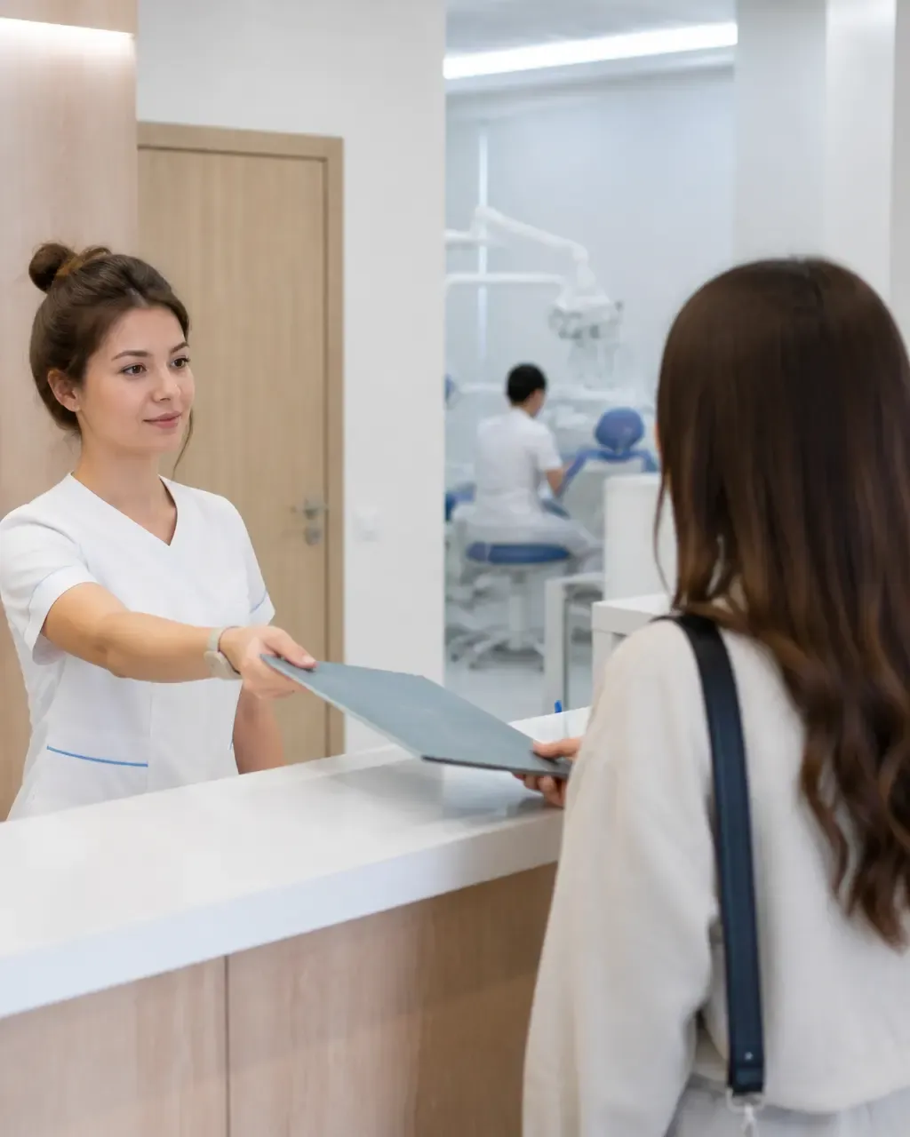 The clinic administrator gives the patient a treatment plan at the front desk