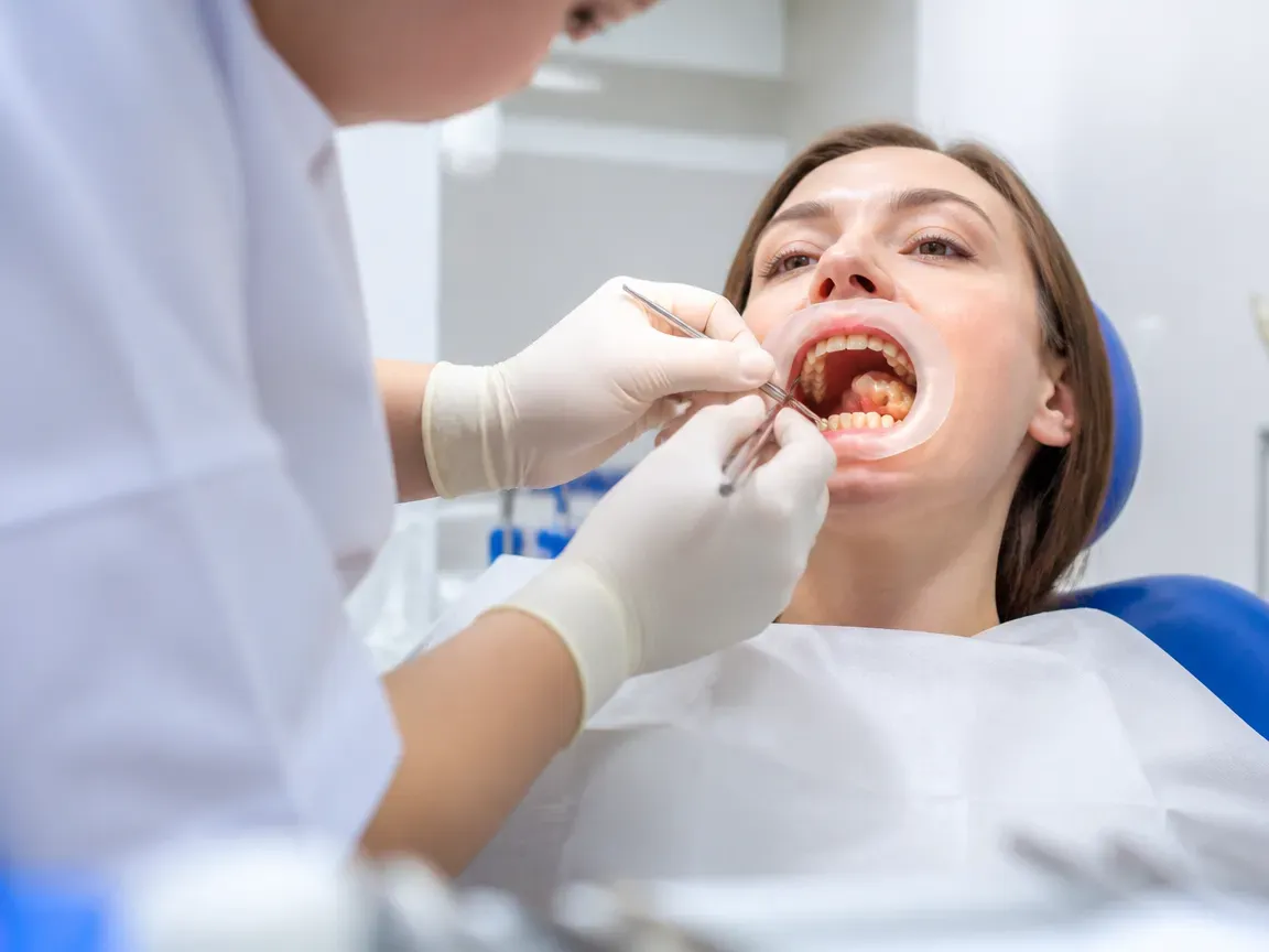 The treatment stage itself: the doctor's gloved hands working in the oral cavity — an illustration for the section "Fabrication in the laboratory"