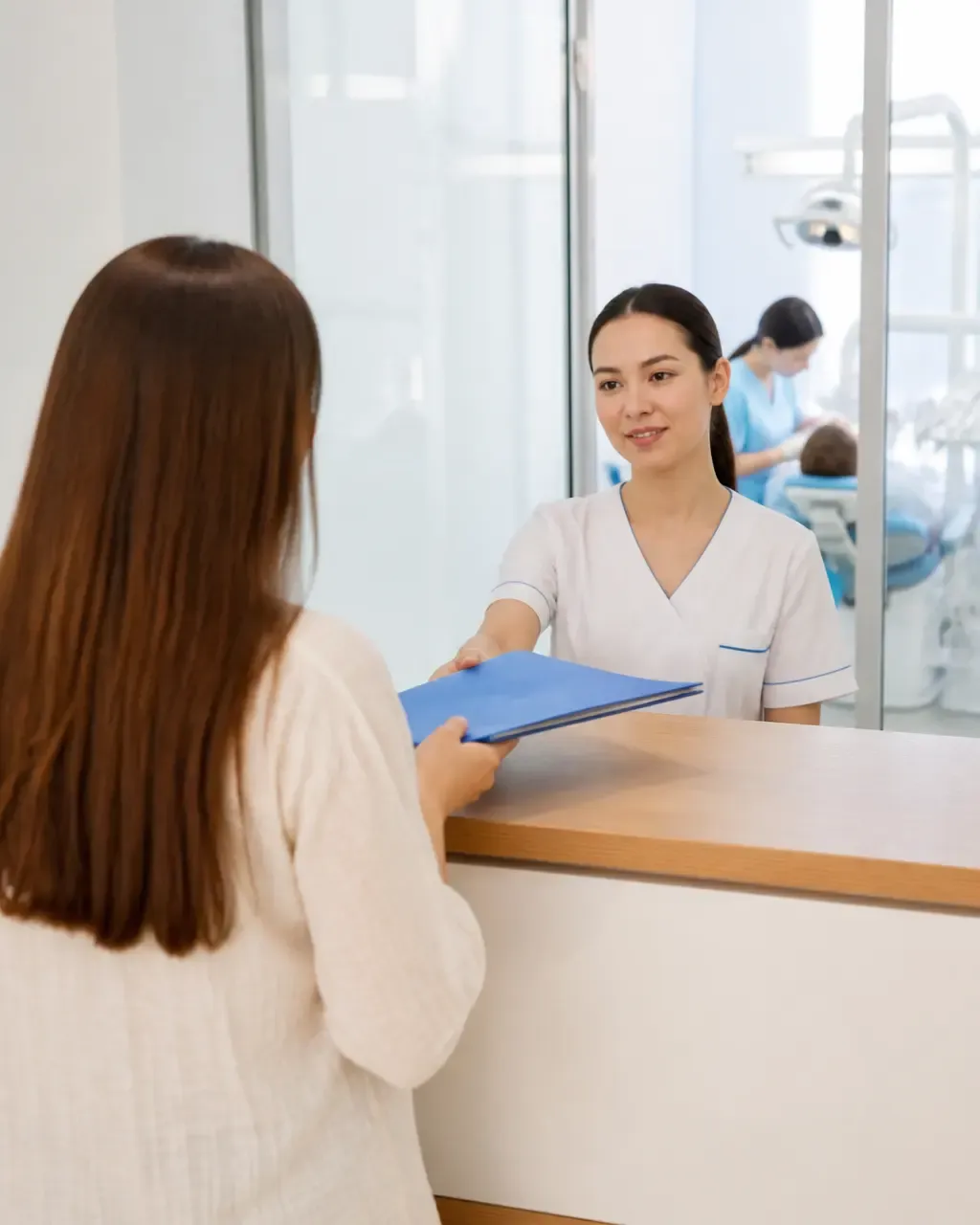 The clinic administrator gives the patient a treatment plan at the front desk