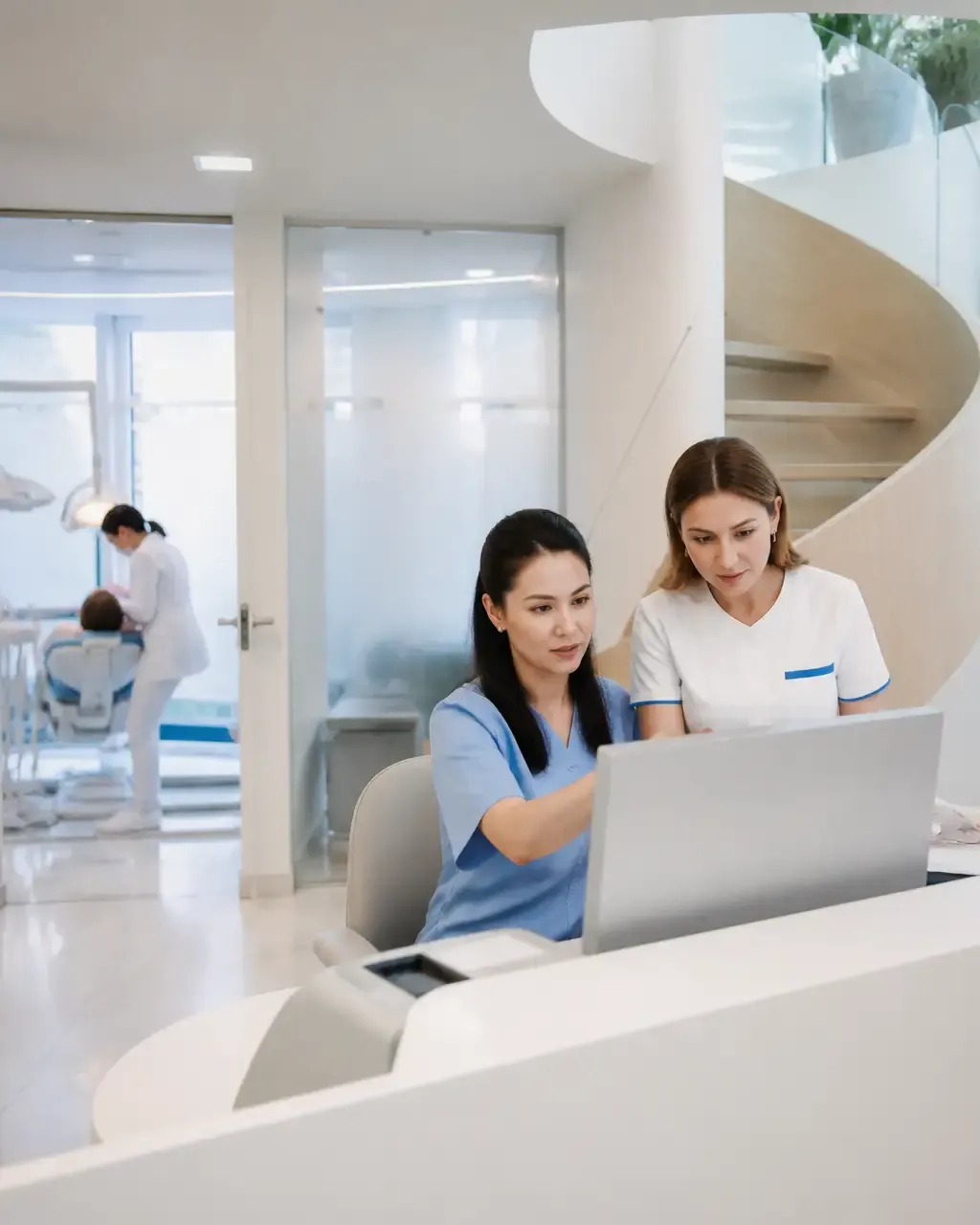 Clinic administrators check the appointment schedule on the screen at the front desk