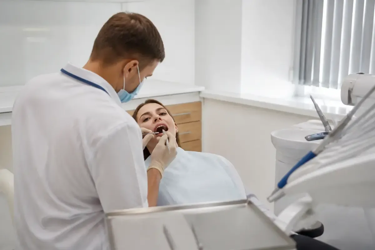 Chairside appointment: dentist at work, over-the-shoulder shot of the assistant — illustration for the "At-Home Whitening" section