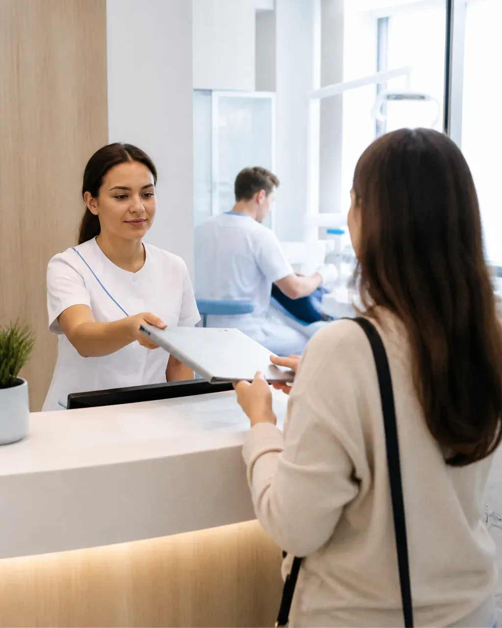 The clinic administrator gives the patient a treatment plan at the front desk