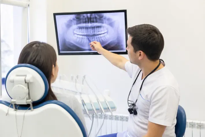 The doctor shows the patient the scan on the screen and explains the treatment plan — illustration for the section "Who chooses the method"