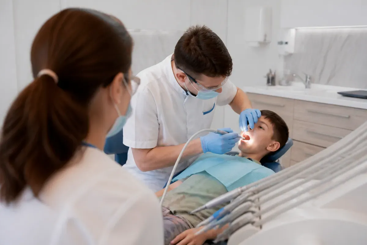 Chairside view: dentist at work, over-the-shoulder shot of the assistant — illustration for the section "Frenectomy and Frenuloplasty"