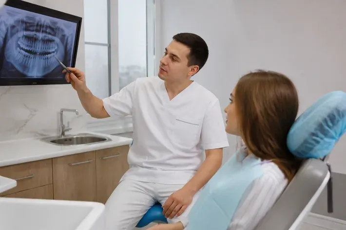 Doctor shows the patient the scan on the screen and explains the treatment plan — illustration for the section "Contraindications and who performs it"