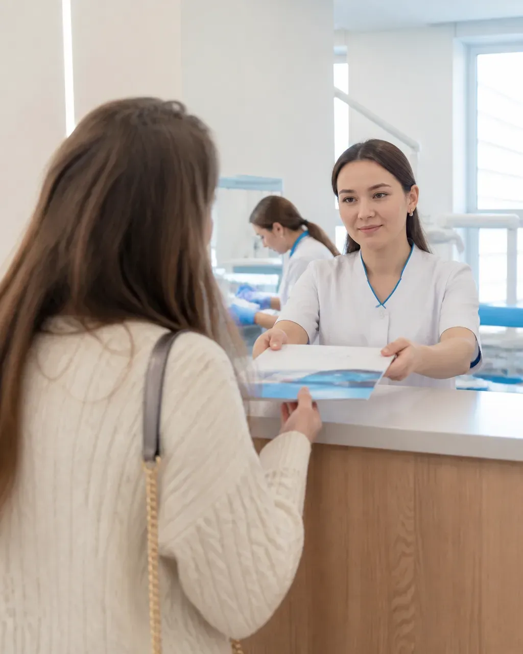 The clinic administrator gives the patient a treatment plan at the front desk