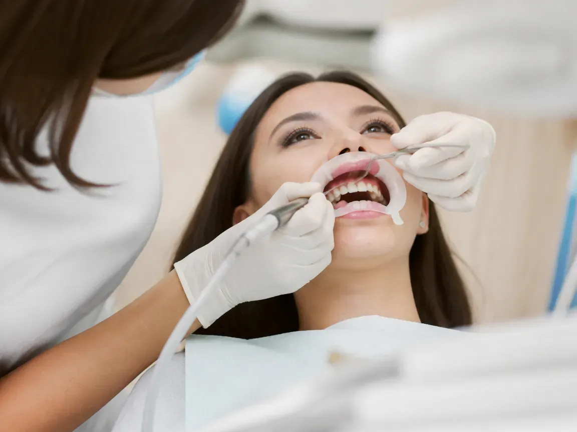 The treatment stage itself: the doctor's gloved hands working in the oral cavity — an illustration for the section "Impressions and fabrication of the restoration"