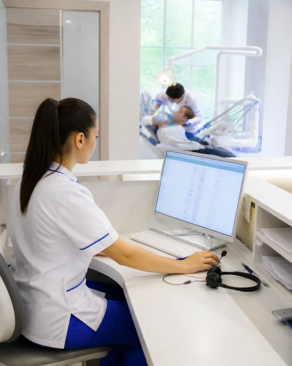 The clinic administrator answers patient messages at the front desk