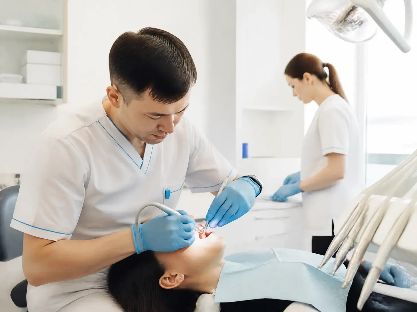 dental restorations Astana — dentist showing a patient a treatment plan on a screen in a bright office