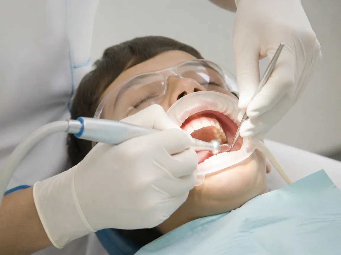 The treatment stage itself: the doctor's gloved hands working in the oral cavity — an illustration for the "Tooth Preparation" section