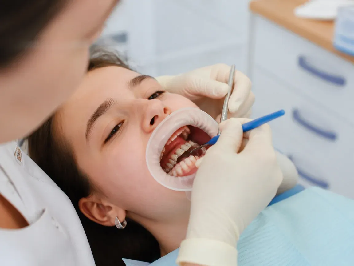 The treatment stage itself: the doctor's gloved hands working in the oral cavity — an illustration for the section "Fabrication of the restoration"