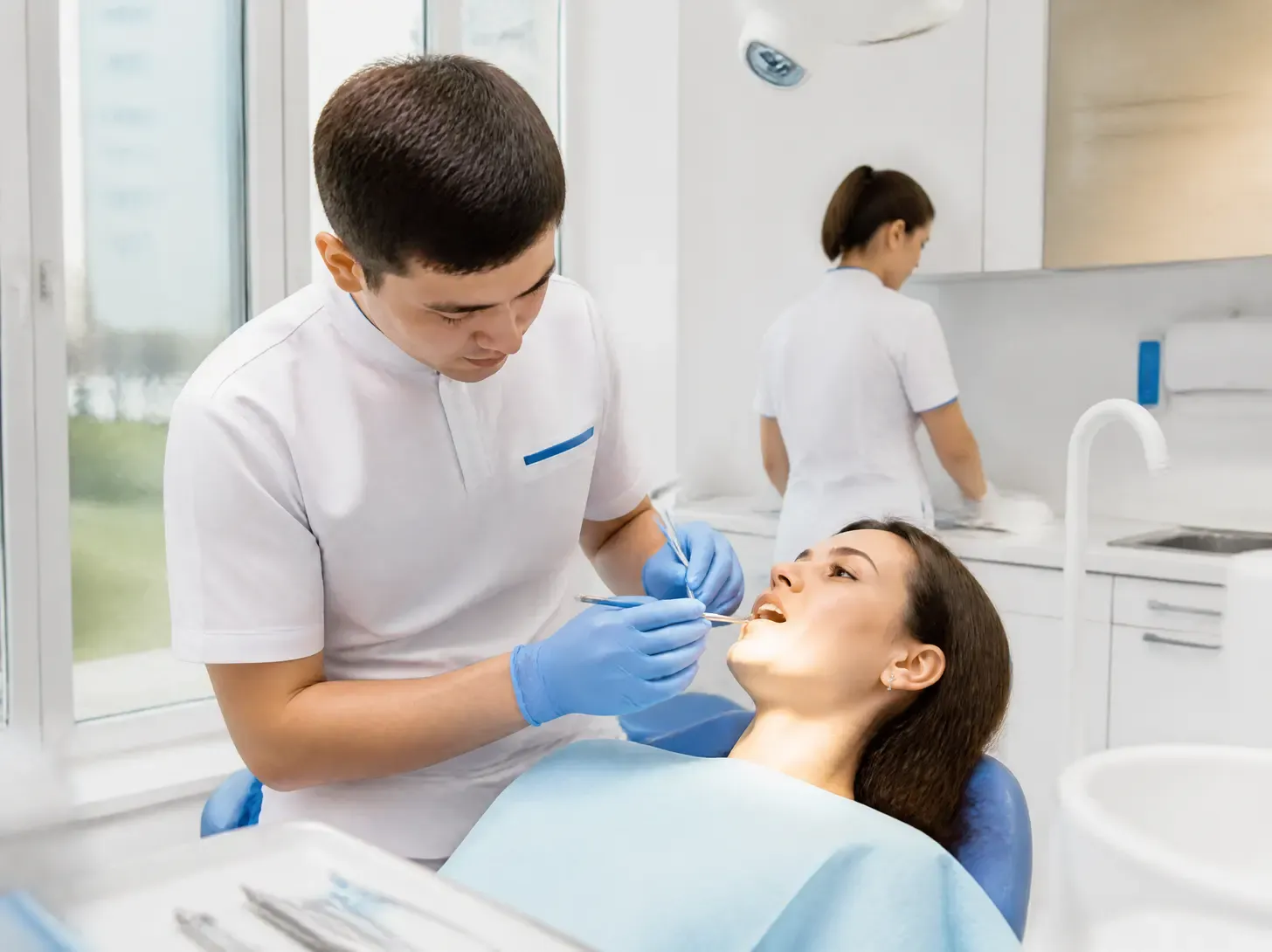 teeth splinting Almaty — dentist showing a patient a treatment plan on a screen in a bright office