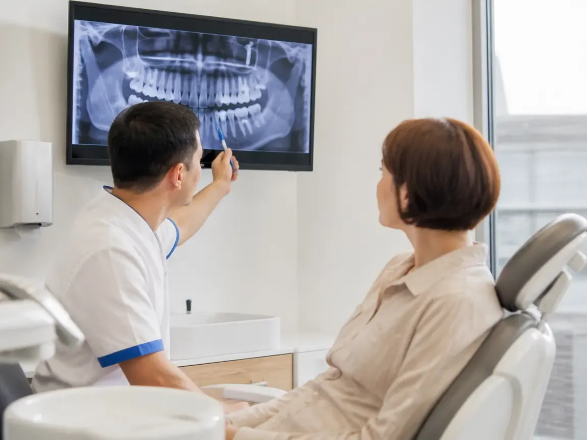 Кеңес: дәрігер мен пациент рентген суреті бар экран алдында — «Кеңес және диагностика» бөліміне иллюстрация