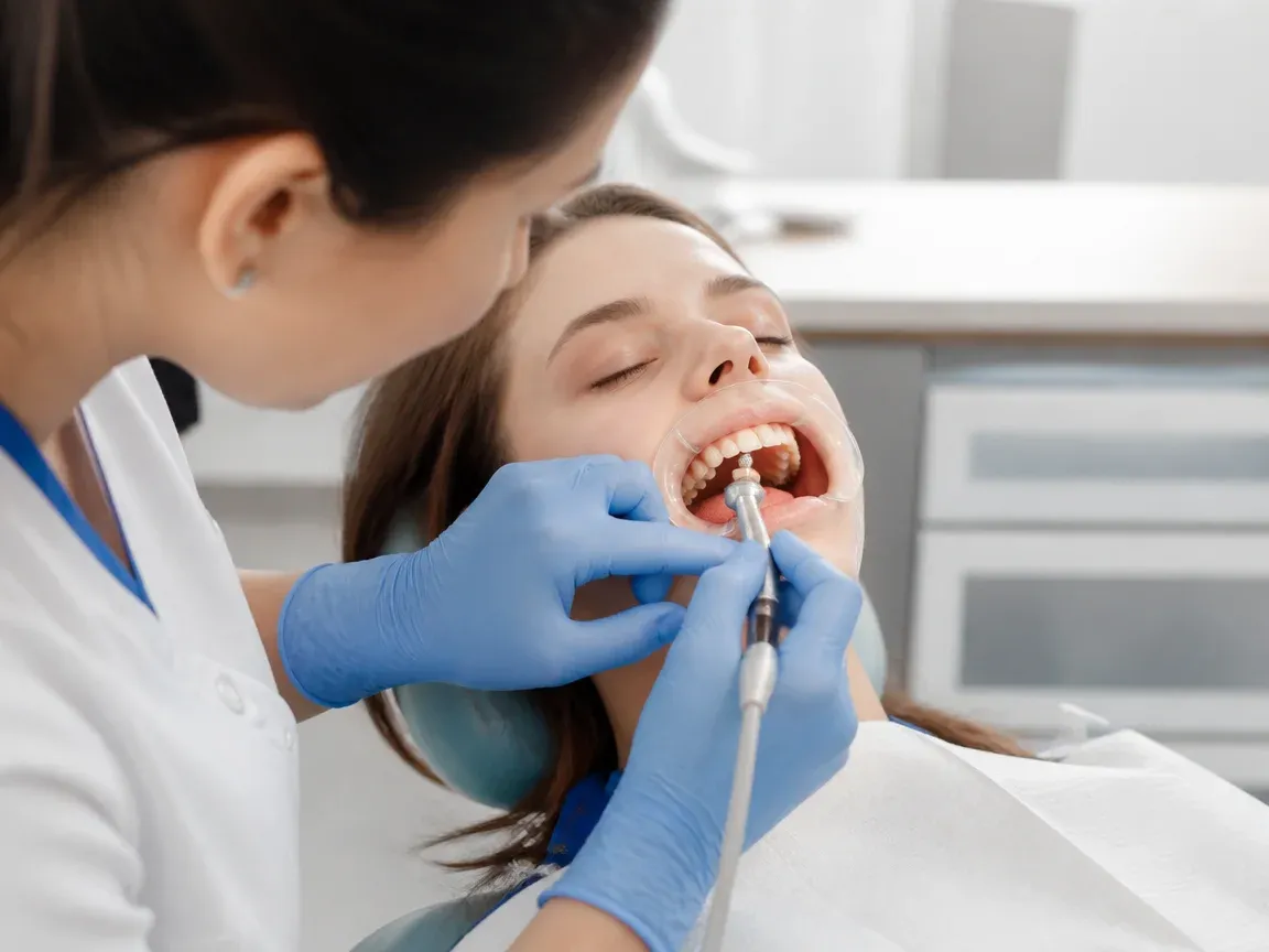 The treatment stage itself: the doctor's gloved hands working in the oral cavity — an illustration for the section "Fixation of Skyce brackets on teeth"