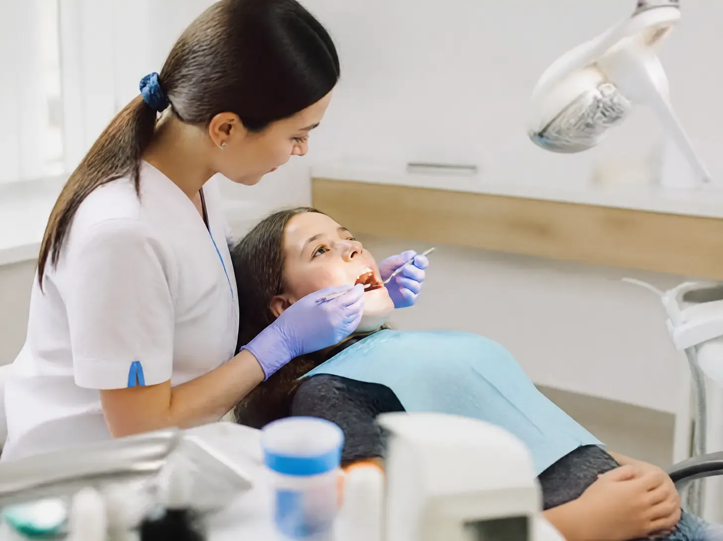 composite filling — the dentist shows the patient the treatment plan on a screen in a bright office