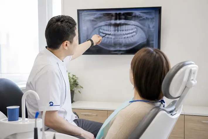 The doctor shows the patient the scan on the screen and explains the treatment plan — an illustration for the "Contraindications" section