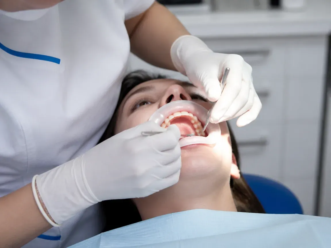 The treatment stage itself: the doctor's gloved hands working in the oral cavity — an illustration for the "Getting Started with Wear" section