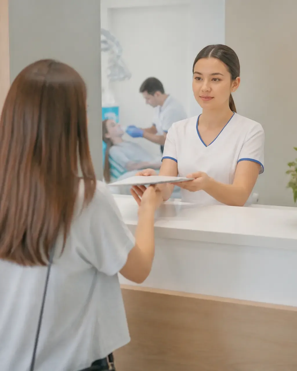 The clinic administrator gives the patient a treatment plan at the front desk