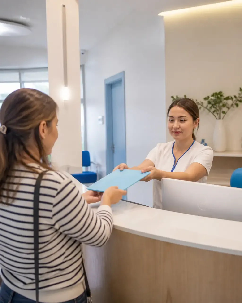 The clinic administrator gives the patient a treatment plan at the front desk