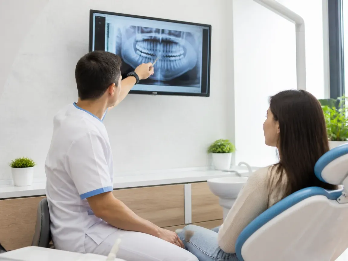 Consultation: doctor and patient at a screen with an X-ray — illustration for the section “Initial examination and diagnostics”